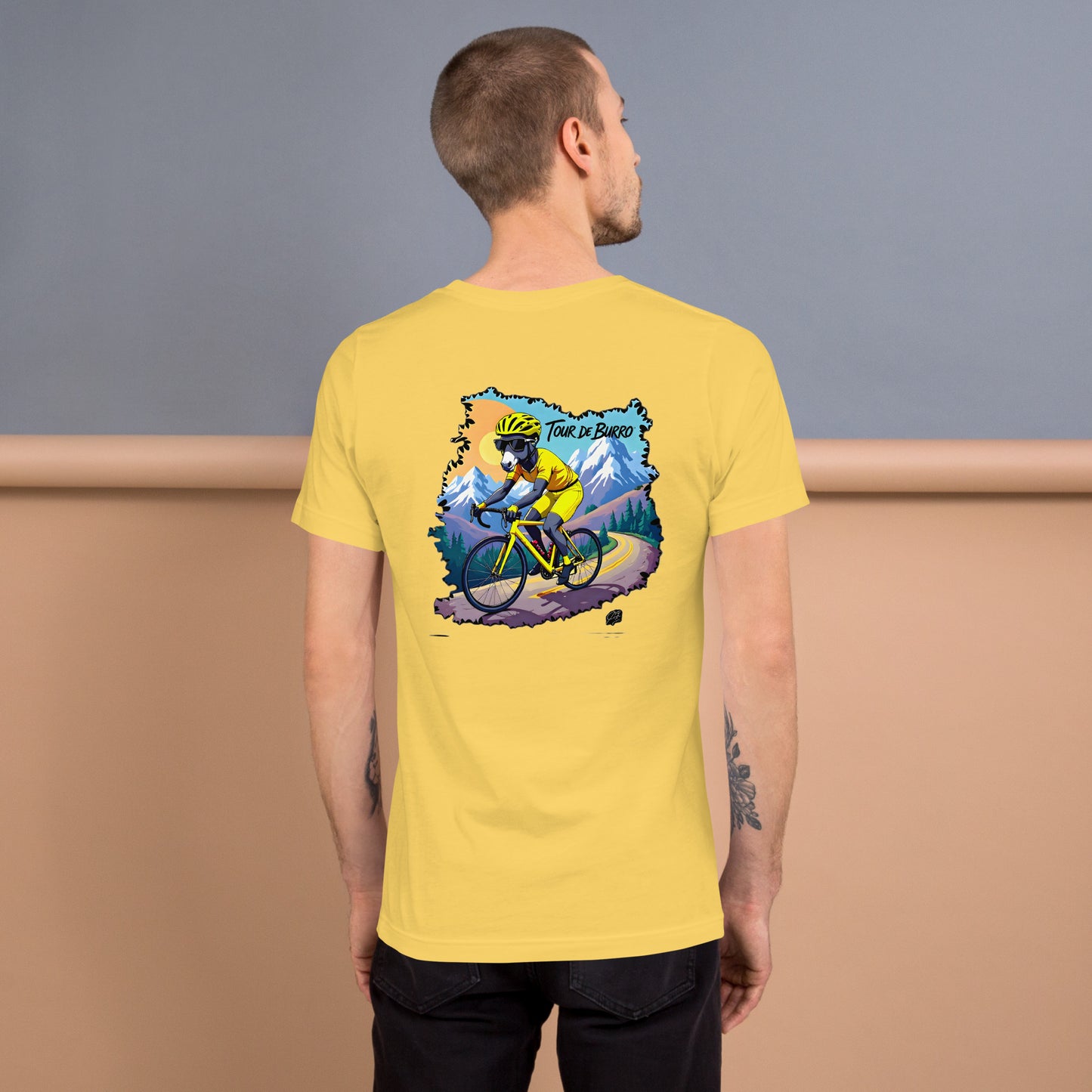 Man wearing a yellow t-shirt with a graphic of a cyclist on the back, standing against a plain background.